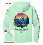 Light green hoodie with disc golf-themed design on the back, featuring mountains and trees, with 'Disc Golf Church' branding.